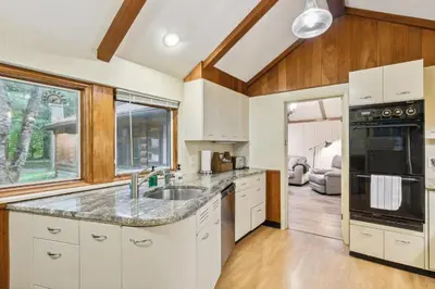 a kitchen with white cabinets and a sink at Log Cabin - Natures Oasis - Fire Pit & Gazebo in Cleveland