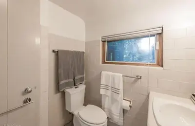 a white bathroom with a toilet and a sink at Log Cabin - Natures Oasis - Fire Pit & Gazebo in Cleveland