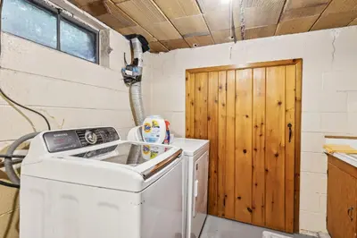 a washer and dryer in a room with a wooden door at Log Cabin - Natures Oasis - Fire Pit & Gazebo in Cleveland