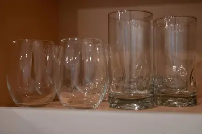 a row of empty glasses sitting on a shelf at Prime OTR off Vine St, Lux Full Bed, Fast WiFi, Fully Equipped, 50in TV, Sleeps 4ppl in Cincinnati