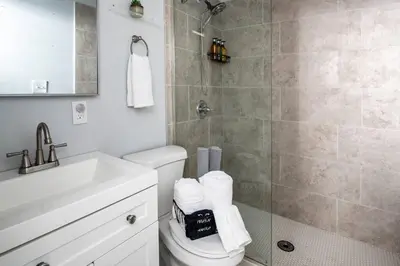 a bathroom with a shower and a toilet and a sink at OTR, QUEEN Bed, 50in TV, Workspace, Near Lightrail in Cincinnati