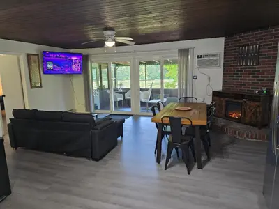 a living room with a table and a couch at Turkey Trot, Cabin Getaway on Lake w/ Hot Tub in Streetsboro