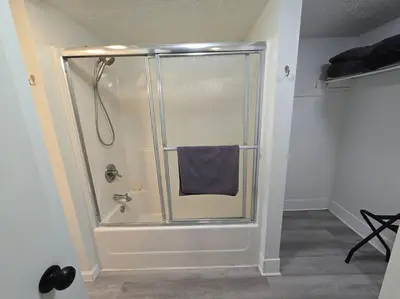 a bathroom with a shower with a blue towel at Eagles Nest At Heron Hill Retreat Hot Tub on Lake! in Streetsboro