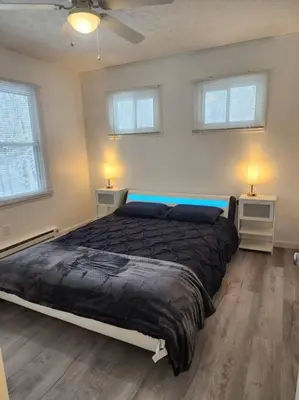 a bedroom with a large bed and two windows at Eagles Nest At Heron Hill Retreat Hot Tub on Lake! in Streetsboro