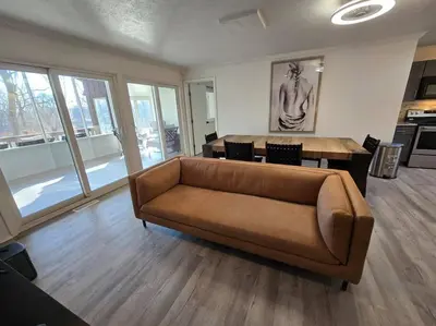 a living room with a brown couch and a table at White Tail Run At Heron Hill Retreat Hot Tub Lake! in Streetsboro