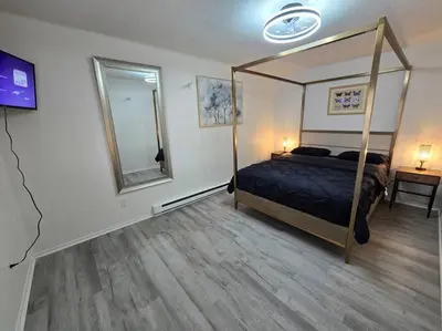 a bedroom with a canopy bed and a mirror at White Tail Run At Heron Hill Retreat Hot Tub Lake! in Streetsboro