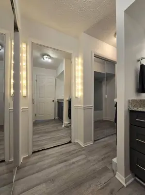 a room with a hallway with a mirror and a bathroom at White Tail Run At Heron Hill Retreat Hot Tub Lake! in Streetsboro