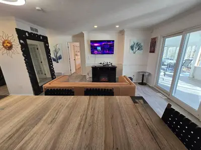 a living room with a large wooden table and a tv at White Tail Run At Heron Hill Retreat Hot Tub Lake! in Streetsboro