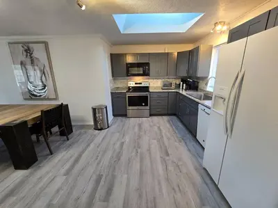 a large kitchen with a table and a refrigerator at White Tail Run At Heron Hill Retreat Hot Tub Lake! in Streetsboro