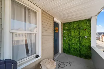 a porch with a bench and a window with a green wall at Pet Friendly 2BR in Little Italy # 3 in Cleveland