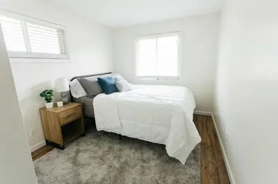 a white bedroom with a bed and two windows at Stylish & Cozy Home in Dayton-Close to Everything! in Dayton