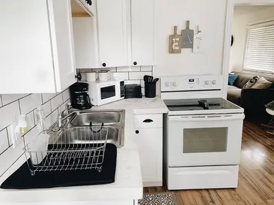 a white kitchen with a sink and a dishwasher at Stylish & Cozy Home in Dayton-Close to Everything! in Dayton