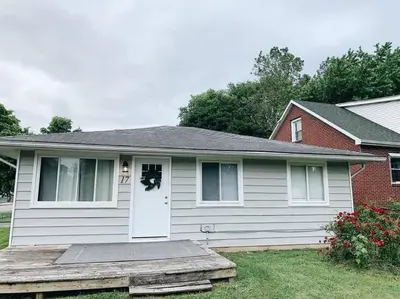 a white house with a porch and a door at Stylish & Cozy Home in Dayton-Close to Everything! in Dayton