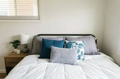 a bed with blue and gray pillows and a window at Stylish & Cozy Home in Dayton-Close to Everything! in Dayton