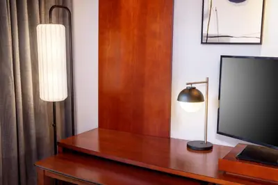 a room with a television and a lamp on a table at Courtyard by Marriott Charleston Downtown/Civic Center in Charleston