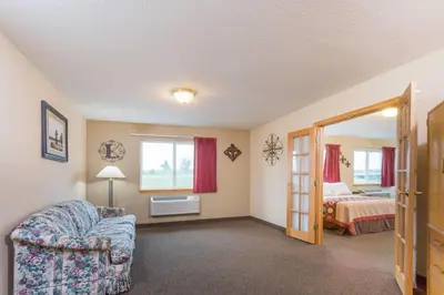 a room with a chair and a bed and a mirror at Super 8 by Wyndham Gallipolis Pt Pleasant Area in Gallipolis