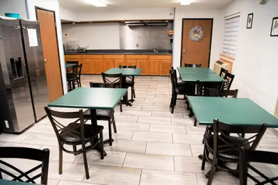 a dining room with green tables and chairs at Super 8 by Wyndham Gallipolis Pt Pleasant Area in Gallipolis