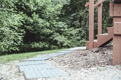a stone walkway with a bench in a park at King Bed House w Private Hot Tub in South Bloomingville