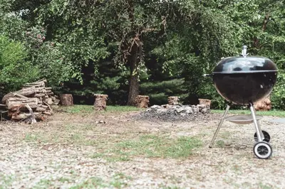 a grill sitting on a stand in a yard at King Bed House w Private Hot Tub in South Bloomingville