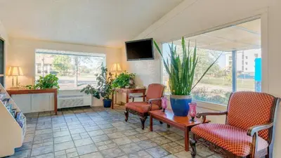 a living room with chairs and a table and a tv at Hilliard Motor Lodge in Hilliard