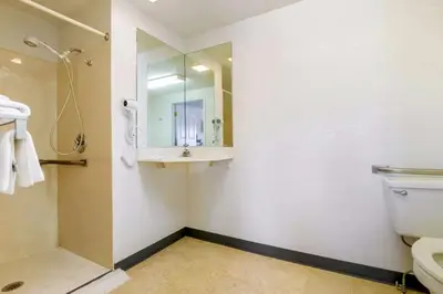 a bathroom with a toilet and a sink and a mirror at Hilliard Motor Lodge in Hilliard