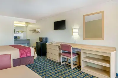 a hotel room with a bed and a desk at Hilliard Motor Lodge in Hilliard