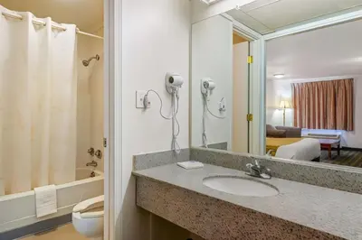 a bathroom with a sink and a toilet and a mirror at Hilliard Motor Lodge in Hilliard