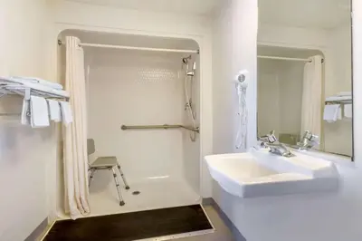 a white bathroom with a sink and a shower at Hilliard Motor Lodge in Hilliard