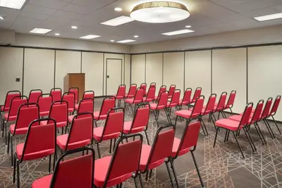 a conference room with red chairs and a podium at Ramada by Wyndham Beaver Falls in Beaver Falls