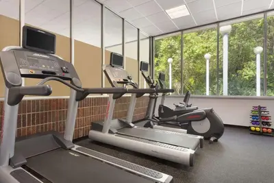 a gym with two exercise bikes and a treadmill at Ramada by Wyndham Beaver Falls in Beaver Falls