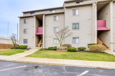 a building with pink balconies on the side of it at Lakefront Port Clinton Condo with Boat Dock and Slip! in Port Clinton