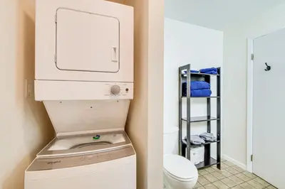 a bathroom with a washer and dryer next to a toilet at Lakefront Port Clinton Condo with Boat Dock and Slip! in Port Clinton
