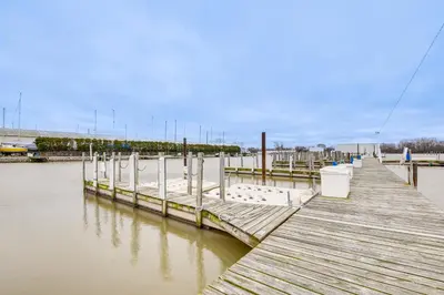 a wooden dock in the water next to a body of water at Lakefront Port Clinton Condo with Boat Dock and Slip! in Port Clinton