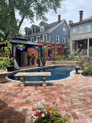 a swimming pool with a bench in front of a house at Mike & Allen's Place on the Park_1 in Columbus