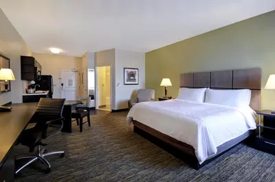 a hotel room with a bed and a desk at Candlewood Suites Carrollton by IHG in Carrollton