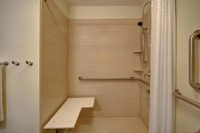 a small bathroom with a shower and a sink at Candlewood Suites Carrollton by IHG in Carrollton