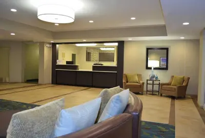 a lobby with a waiting room with chairs and a table at Candlewood Suites Carrollton by IHG in Carrollton
