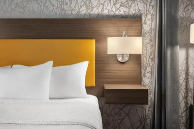 a bedroom with a bed and a yellow headboard at Home2 Suites By Hilton Cincinnati Eastgate in Cincinnati
