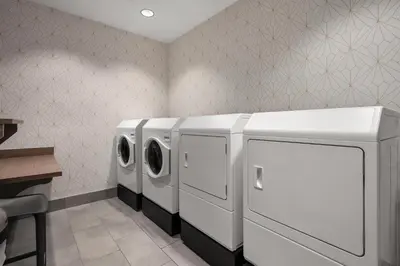 a laundry room with three washing machines and a counter at Home2 Suites By Hilton Cincinnati Eastgate in Cincinnati