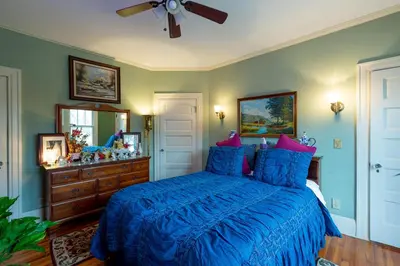 a bedroom with a blue bed and a ceiling fan at Mike & Allen's Place on the Park_2 in Columbus