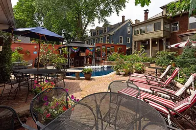 a patio with tables and chairs and a table with an umbrella at Mike & Allen's Place on the Park_3 in Columbus