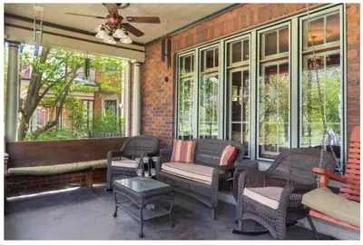 a screened in porch with wicker furniture and windows at Mike & Allen's Place on the Park_3 in Columbus