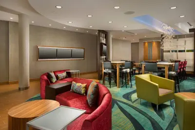 a hotel lobby with chairs and a dining room at SpringHill Suites by Marriott Bridgeport Clarksburg in Bridgeport