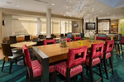 a conference room with a wooden table and red chairs at SpringHill Suites by Marriott Bridgeport Clarksburg in Bridgeport