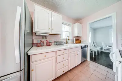 a kitchen with white cabinets and a white refrigerator at Coastal Lake Erie Cottage with Amazing Water Views! in Euclid