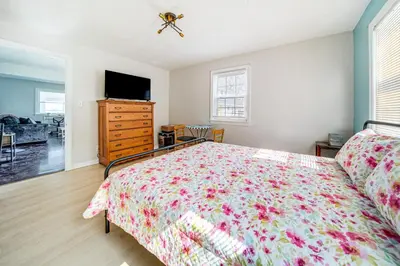 a bedroom with a bed and a dresser and a tv at Coastal Lake Erie Cottage with Amazing Water Views! in Euclid
