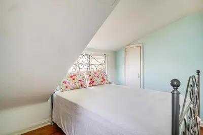 a bedroom with a bed and a window at Coastal Lake Erie Cottage with Amazing Water Views! in Euclid