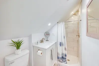 a white bathroom with a toilet and a shower at The Maple Tree Home 14 Mi to Downtown Cleveland in Maple Heights