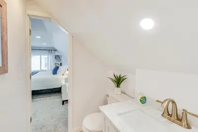 a bathroom with a sink and a toilet and a bed at The Maple Tree Home 14 Mi to Downtown Cleveland in Maple Heights