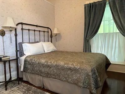 a bedroom with a bed and a window at Iron Gate Inn in Madison